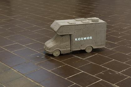 Zu sehen ist ein Miniaturcamper mit der Aufschrift "KOSMOS"